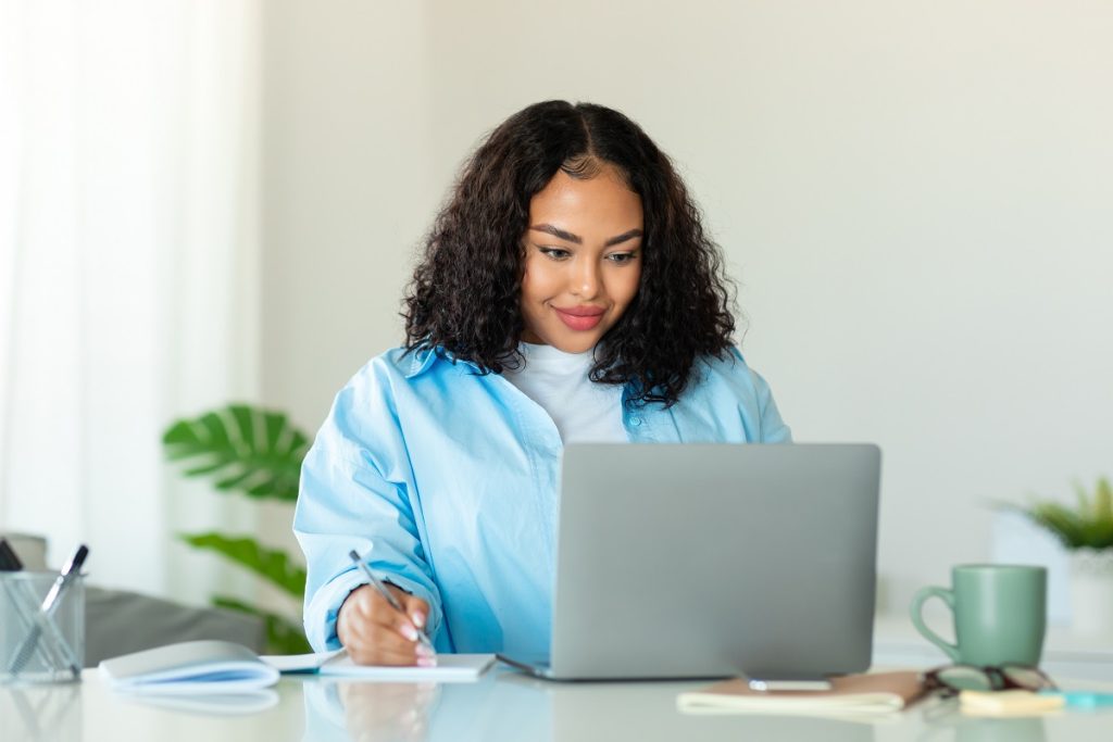 A woman writing resume choosing what to use for resume fonts