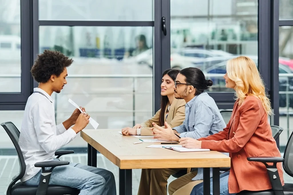 job applicant showing his cover letter to a panel of interviewers