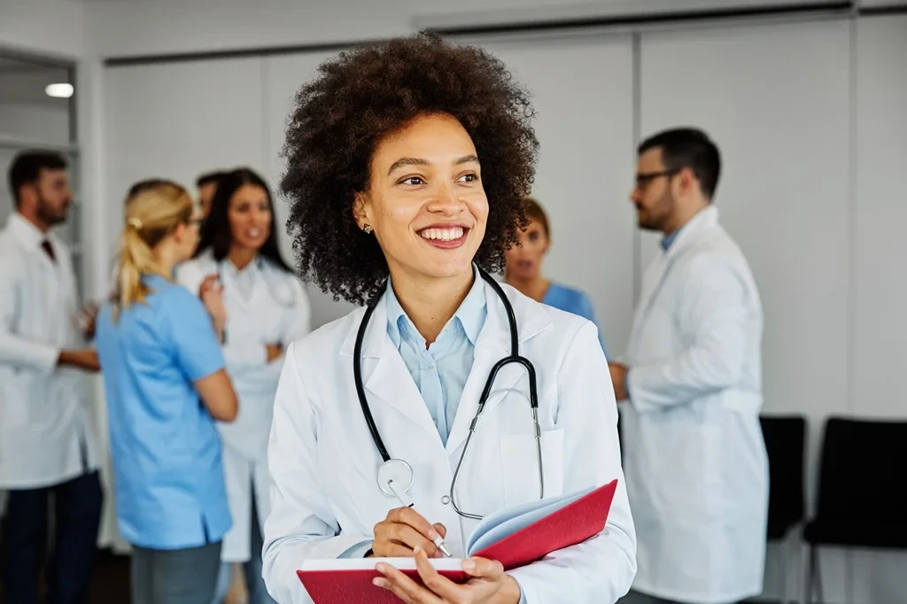 confident physician assistant alongside other healthcare professionals