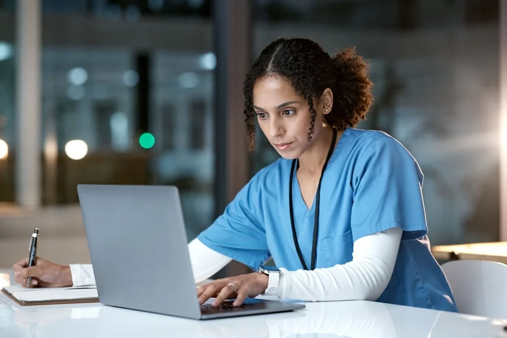 midwife optimizing her resume using a laptop