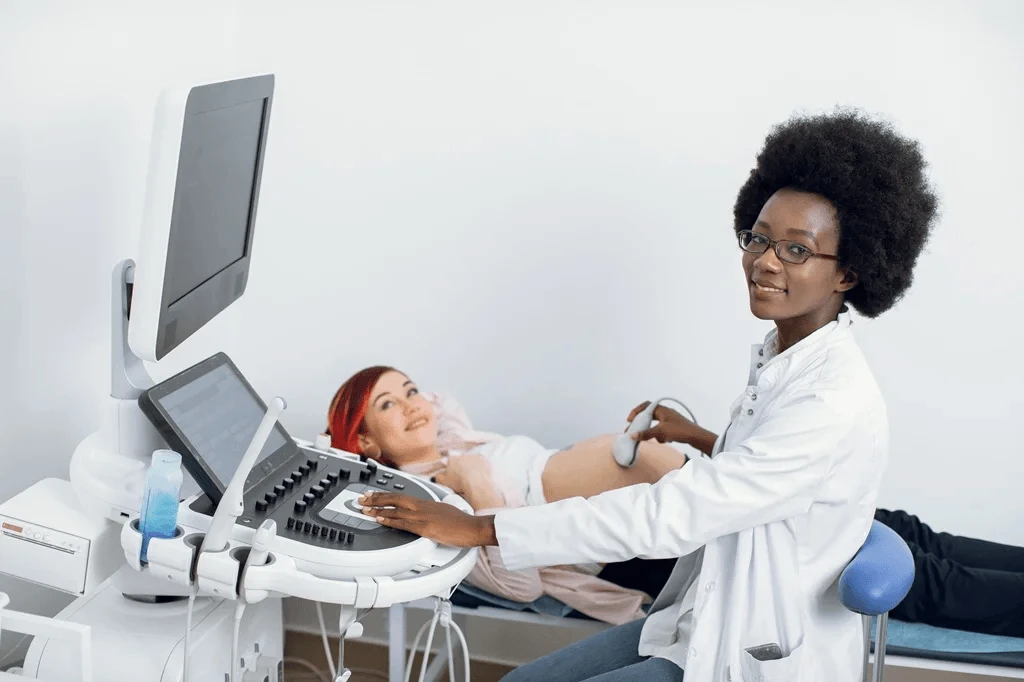 professional midwife performing an ultrasound on a pregnant woman