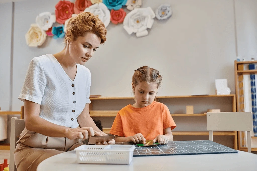 child care worker teaching the young girl to count with chalkboard