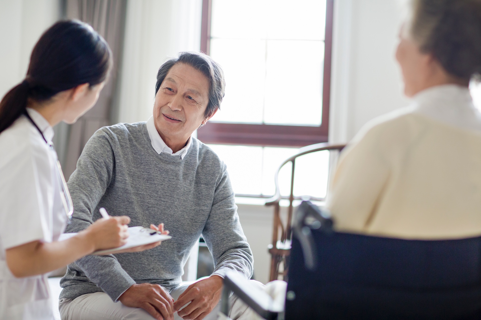 Nursing assistant talking with senior man