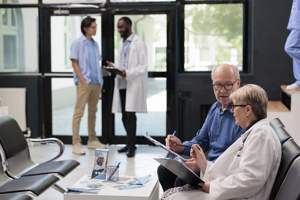 senior doctor discussing patient files with colleague, demonstrating detail-oriented skills