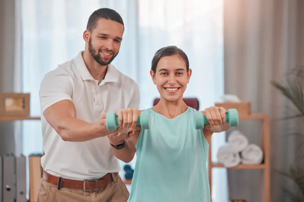Physical therapist assisting patient with weights, highlighting physical therapist resume skills