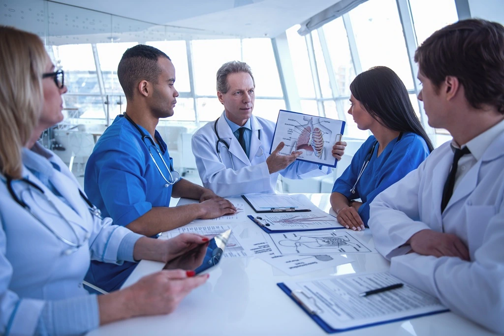medical staff in meeting demonstrating communication and collaboration as core competencies on resume