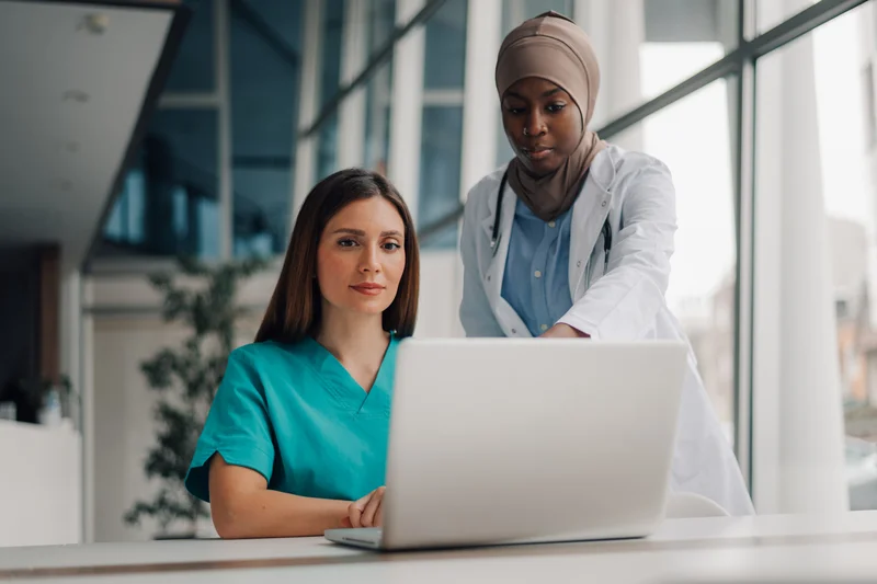 ehr specialist recording data with doctor