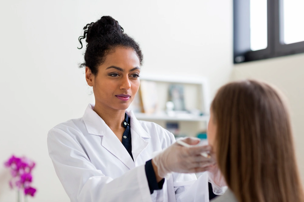 female dermatologist checking patient face