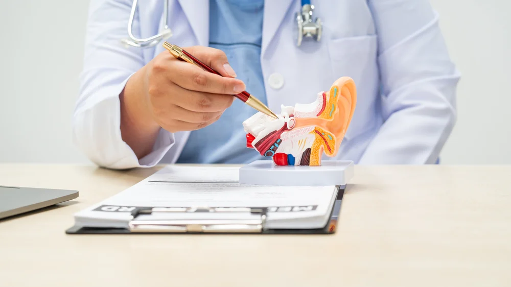 a female doctor sits at a table in a hospital